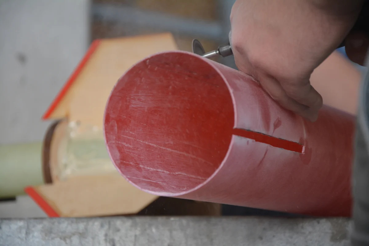 Construction of booster section of Astrohawk II. Cutting fin slots with motor mount assembly in the background.
